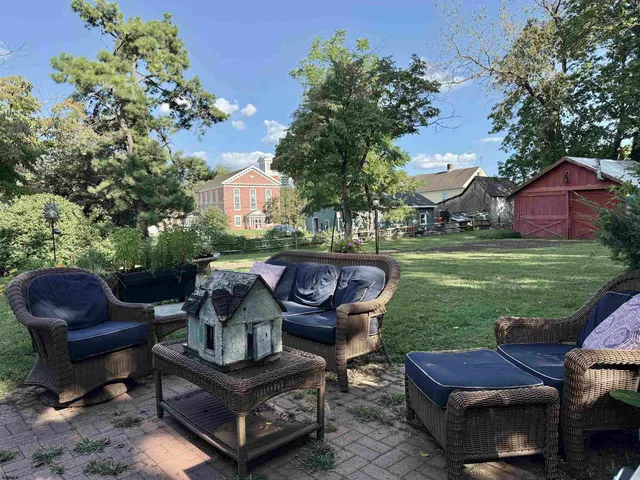 a view of a house with backyard and trees