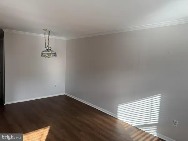 an empty room with wooden floor window and windows