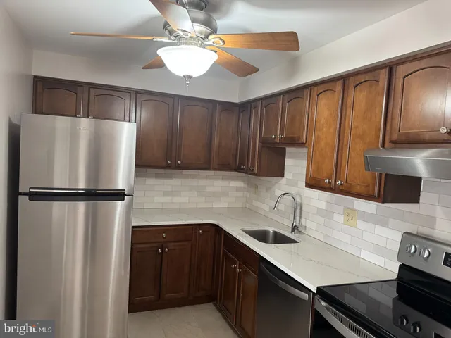 a kitchen with a refrigerator a sink and cabinets