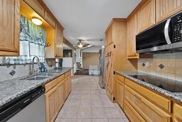 a kitchen with stainless steel appliances granite countertop a sink and a microwave