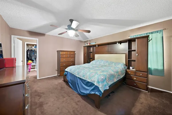 a bedroom with a bed dresser and a window