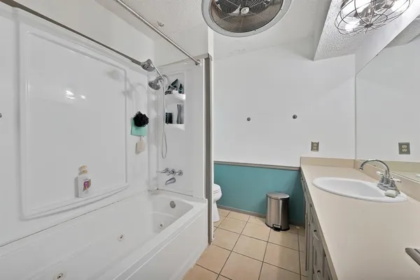 a bathroom with a tub sink and mirror