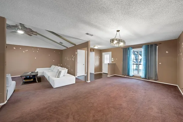 a view of an empty room with window and cabinet