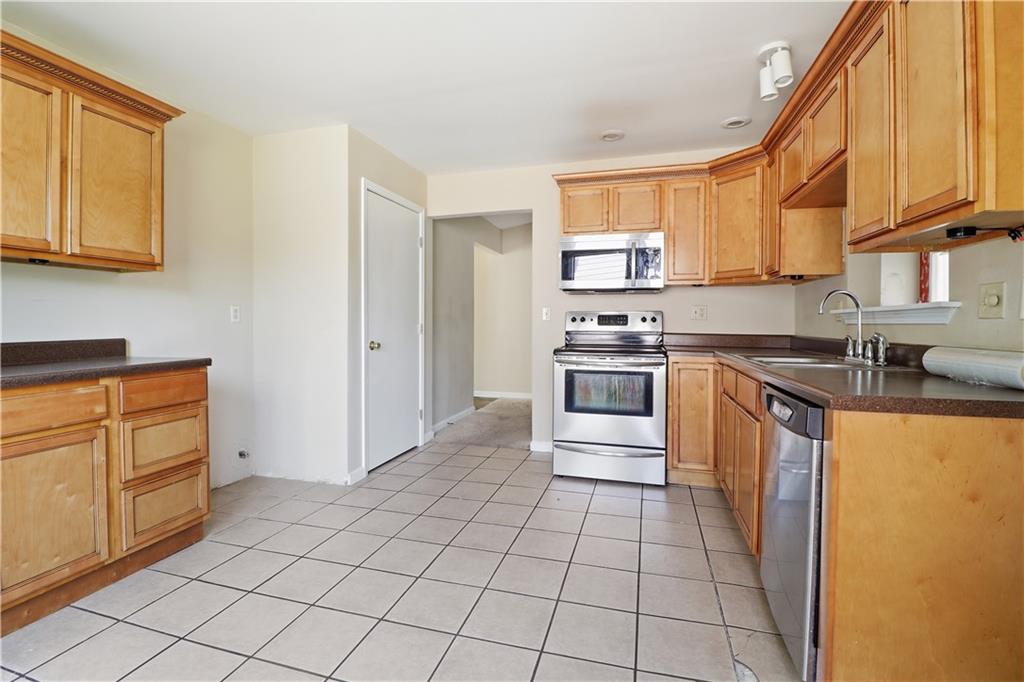 5288 Biffle Downs Road Stone Mountain, GA 30088 - Photo 10 of 18 a kitchen with stainless steel appliances granite countertop a stove a sink and a refrigerator
