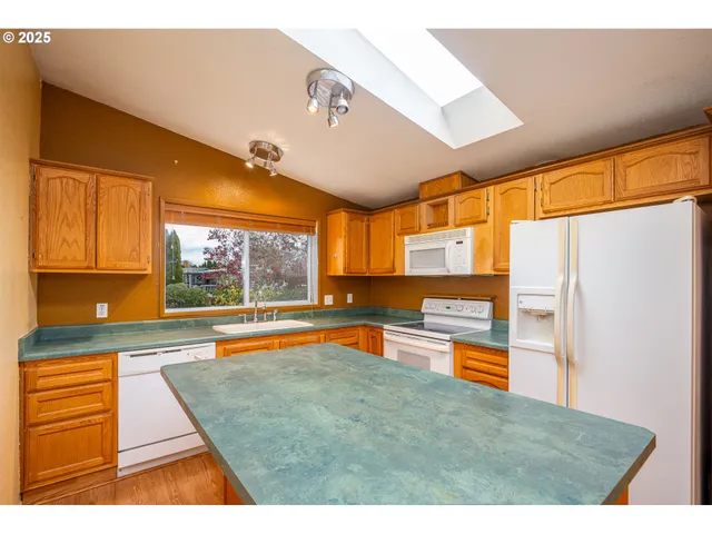a kitchen with stainless steel appliances granite countertop a sink and a refrigerator
