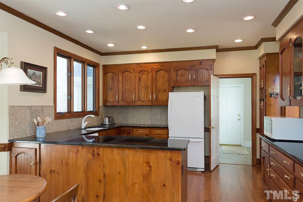 4820 Oak Way Raleigh, NC 27613 - Photo 13 of 25 a kitchen with stainless steel appliances granite countertop a refrigerator a sink and wooden cabinets