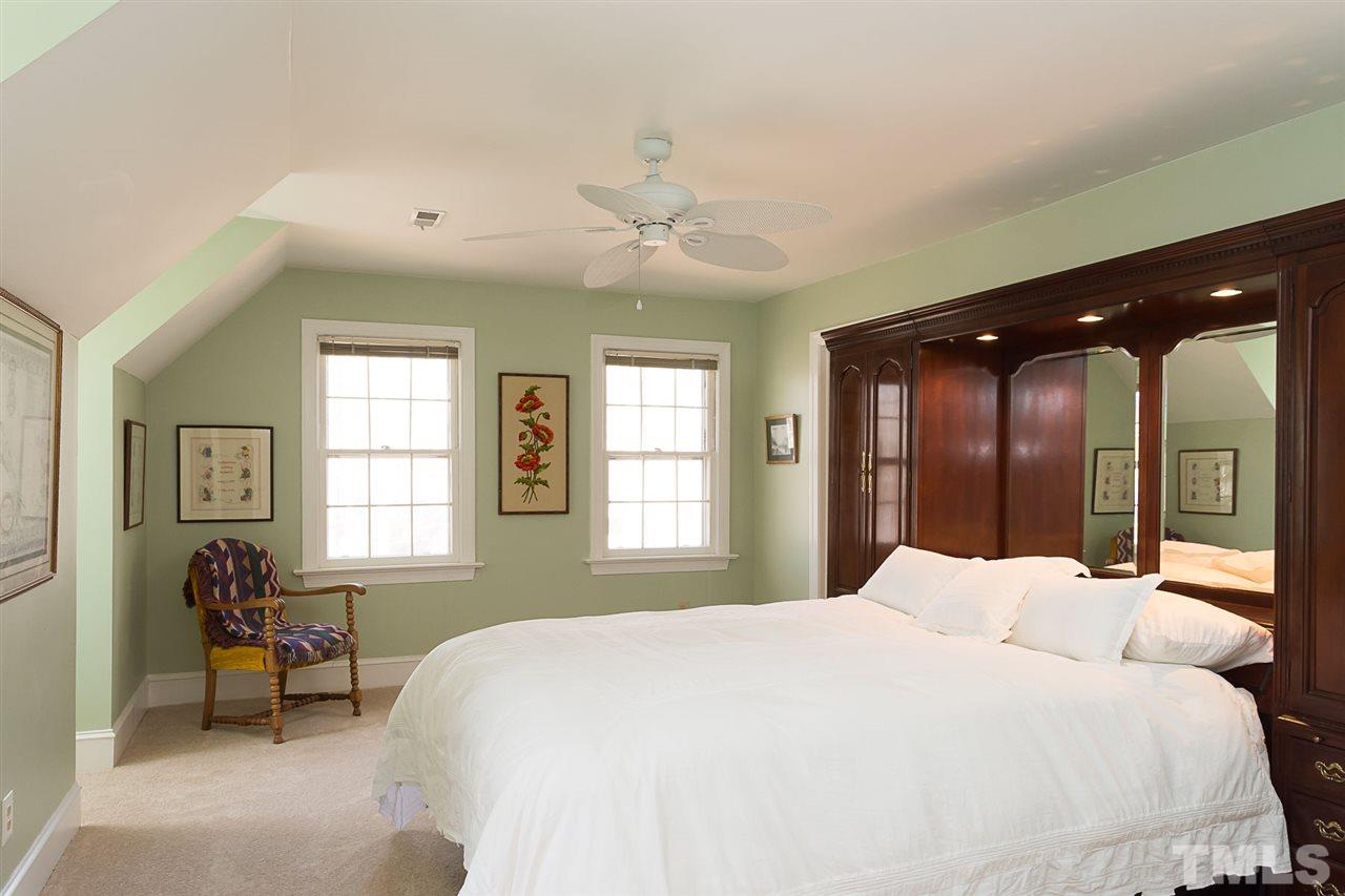 4820 Oak Way Raleigh, NC 27613 - Photo 15 of 25 a spacious bedroom with a large bed and a chandelier fan