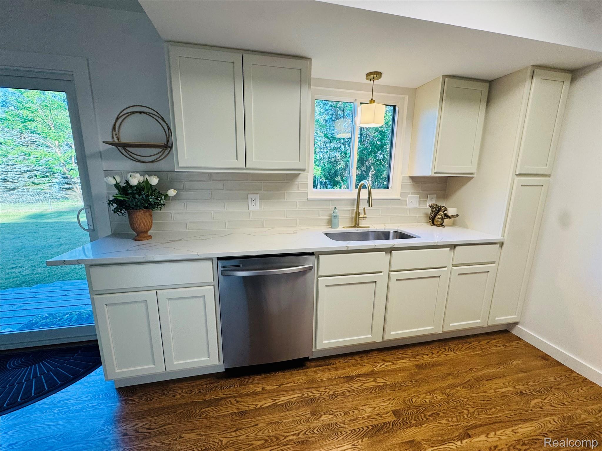 5215 Schlaud Road North Branch, MI 48461 - Photo 7 of 14 Room featuring wood-finish flooring, two large windows, a ceiling-mounted light fixture with a drum shade, and white baseboards