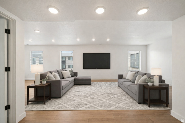 70 East Weekes Way Clearfield, UT 84015 - Photo 2 of 25 Living room featuring light wood-style flooring and healthy amount of natural light. Virtually staged.