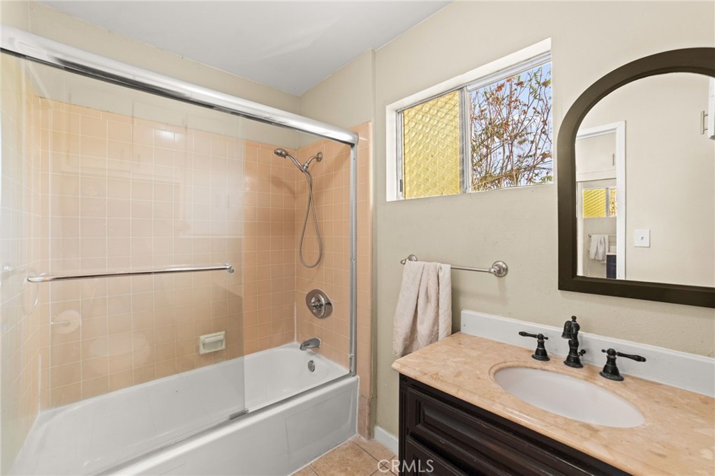 3717 Roosevelt Street Riverside, CA 92503 - Photo 27 of 27 a bathroom with a granite countertop sink a mirror a shower and a bathtub