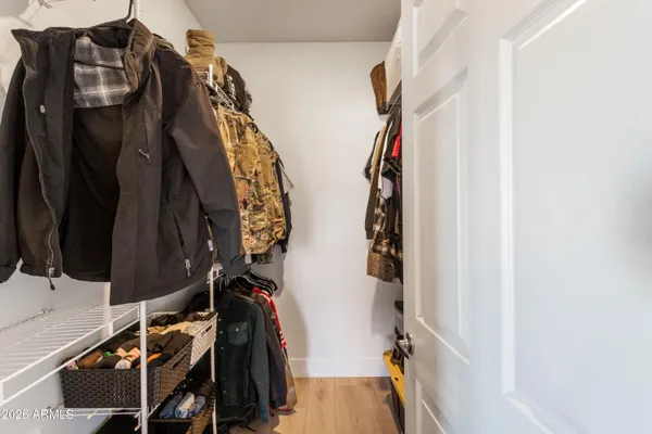 a view of walk in closet with clothes and shoes