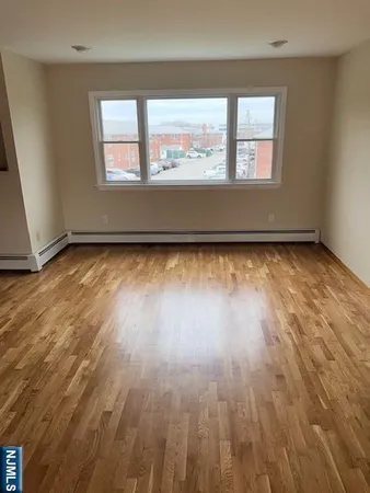 a view of a room with wooden floor and window