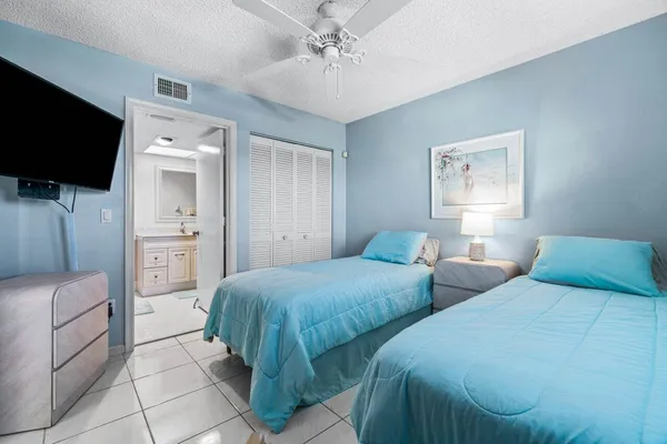 a bedroom with two beds and a flat screen tv