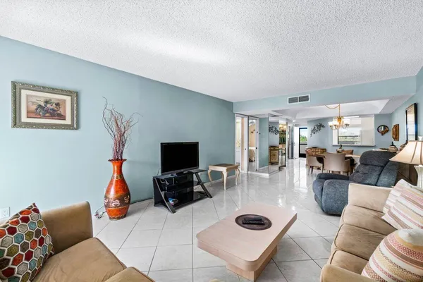 a living room with furniture a flat screen tv and a window