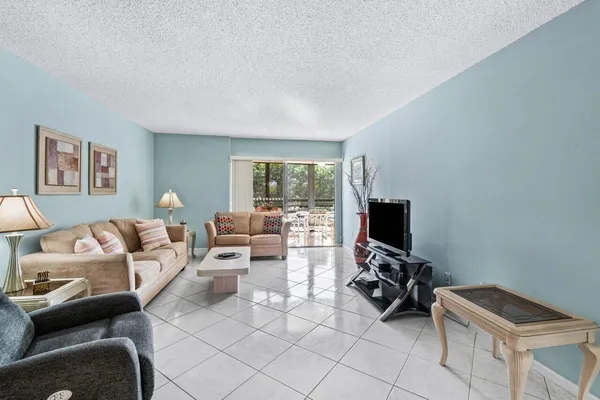 a living room with furniture a flat screen tv and a window