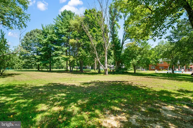 an aerial view of a house with a yard and large tree