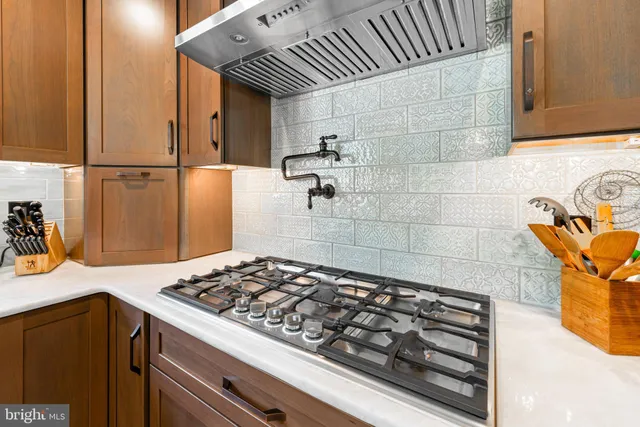 a large kitchen with stainless steel appliances granite countertop a sink and cabinets