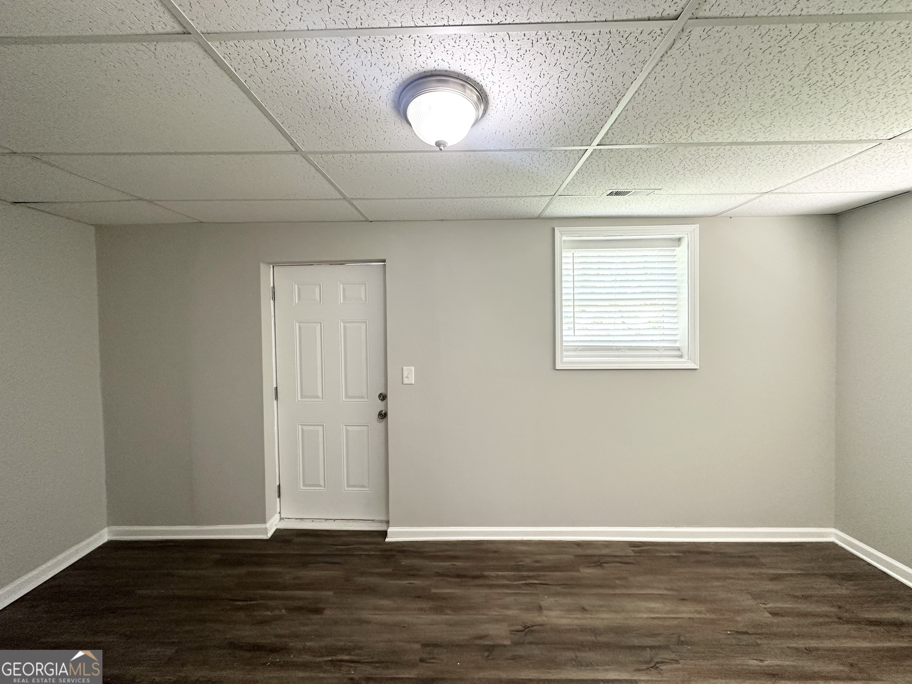 3798 Bakers Ferry Road Southwest Atlanta, GA 30331 - Photo 17 of 21 a view of an empty room with wooden floor and a window