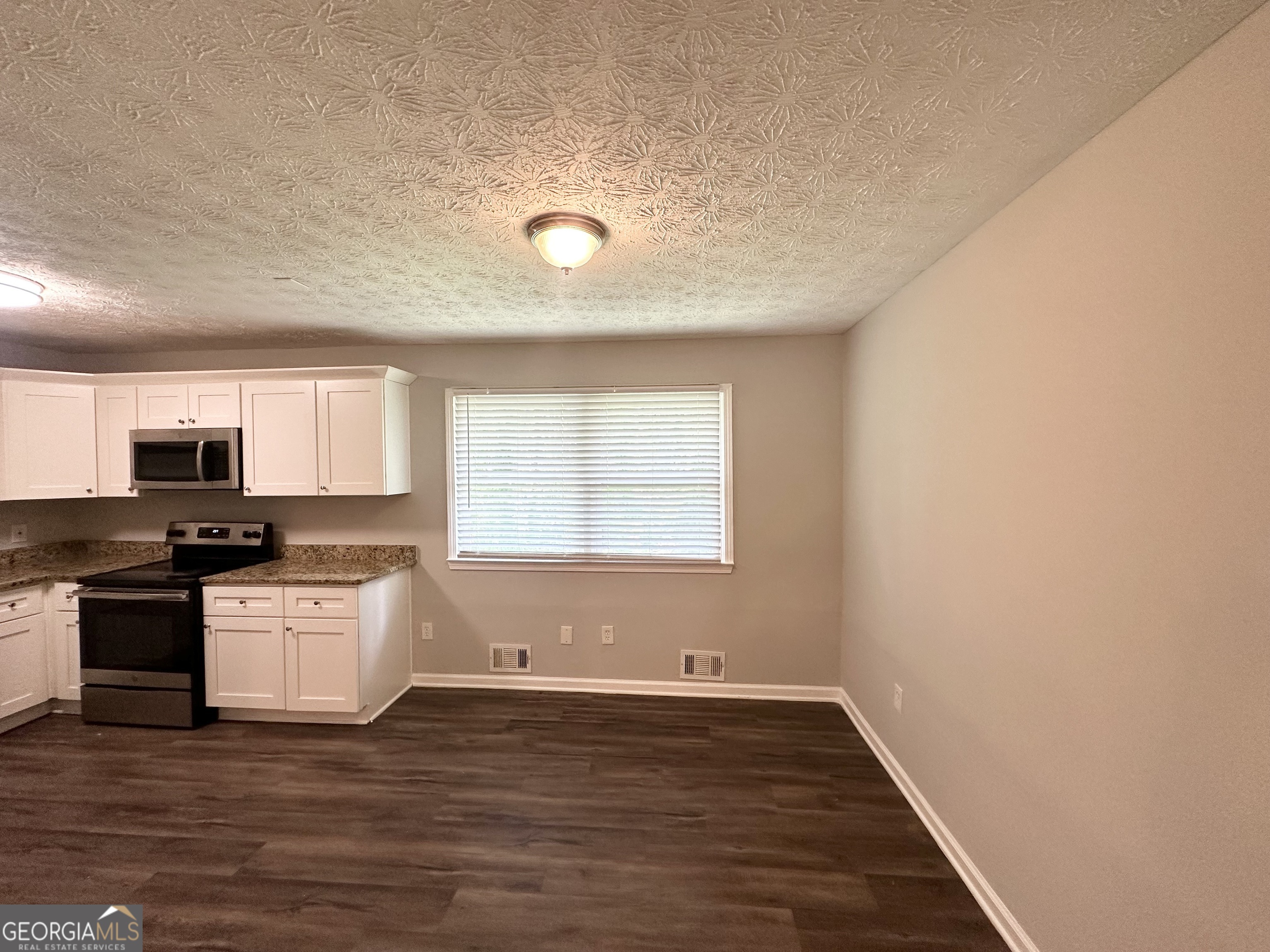 3798 Bakers Ferry Road Southwest Atlanta, GA 30331 - Photo 5 of 21 a view of a kitchen with a stove wooden floor and a window