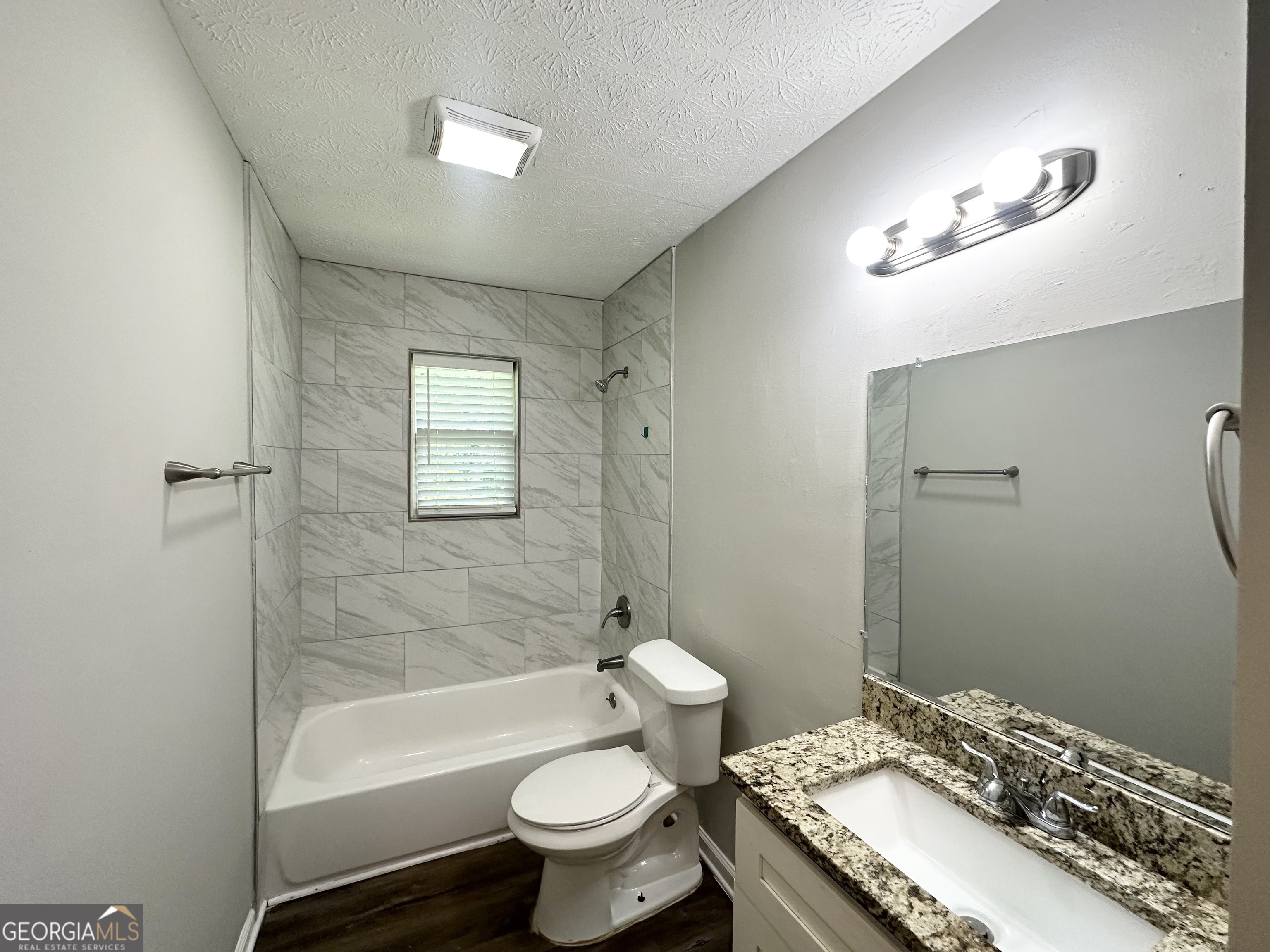 3798 Bakers Ferry Road Southwest Atlanta, GA 30331 - Photo 7 of 21 a bathroom with a granite countertop sink toilet a mirror and a bathtub