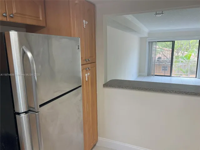 a view of a kitchen with wooden floor and a window