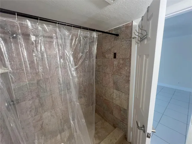 a bathroom with a shower and a glass door