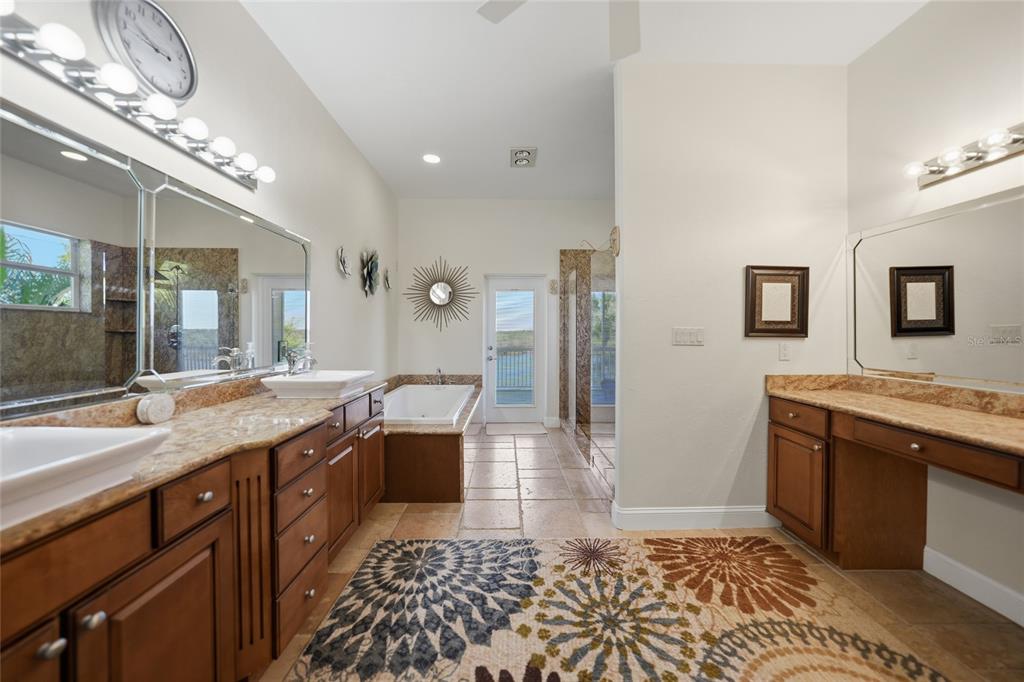 8635 Southwest Riverside Drive Arcadia, FL 34269 - Photo 24 of 70 a large bathroom with a granite countertop sink a toilet a mirror and vanity