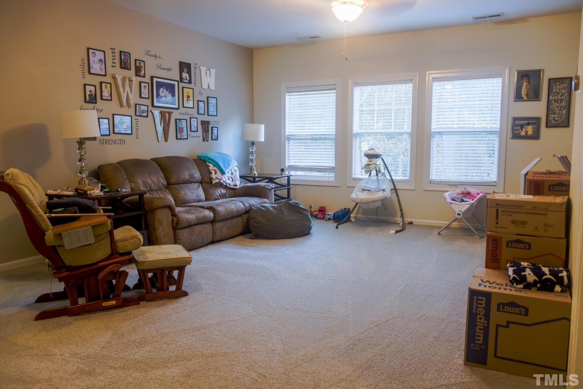 10100 Darling Street Raleigh, NC 27613 - Photo 18 of 24 a living room with furniture a flat screen tv and a window