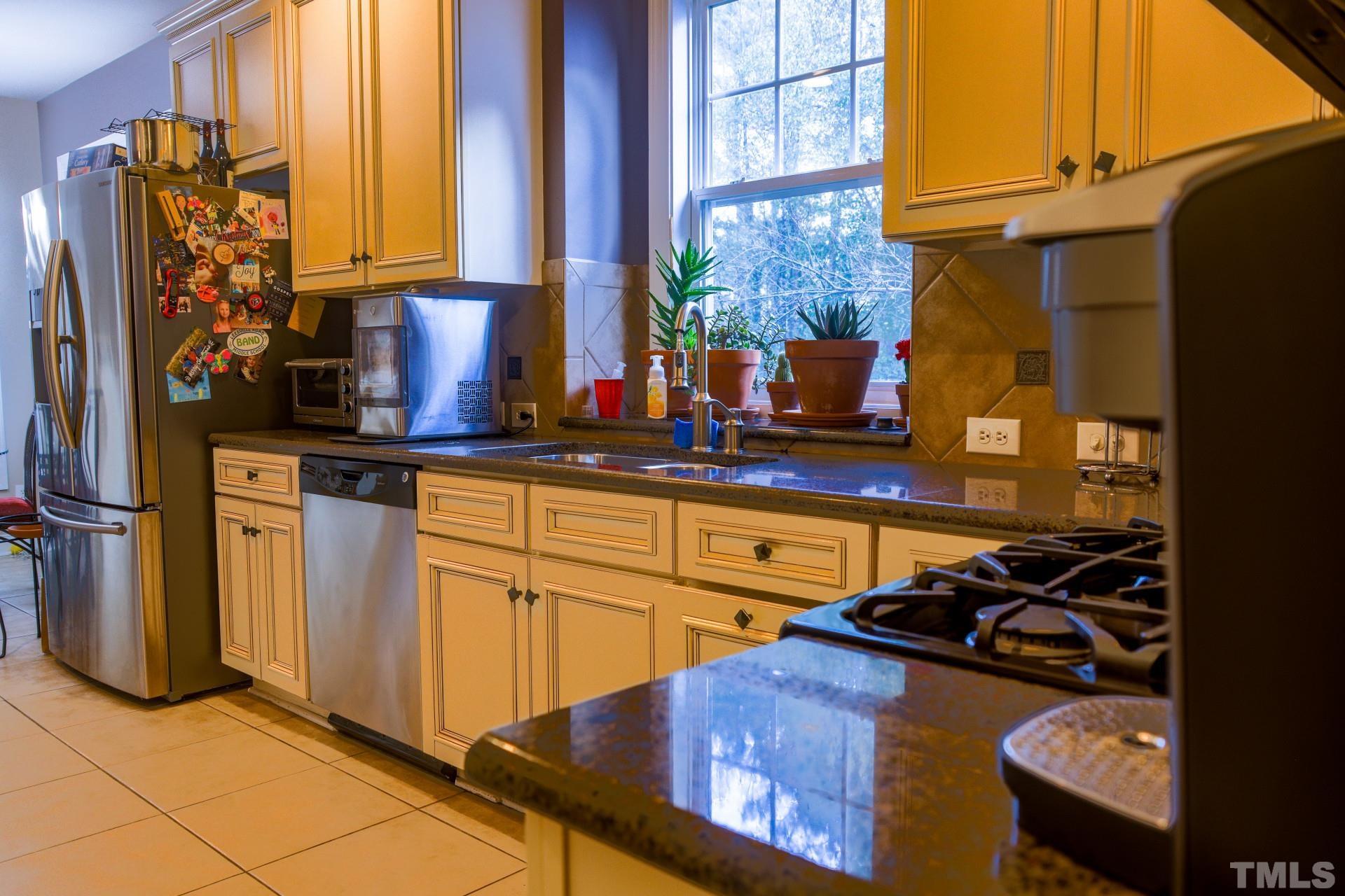 10100 Darling Street Raleigh, NC 27613 - Photo 6 of 24 a kitchen with stainless steel appliances granite countertop a sink stove and cabinets