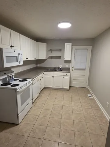 a kitchen with a stove sink and cabinets