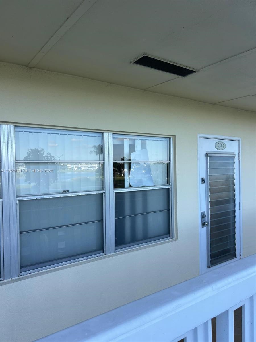 293 Dorset Drive, Unit G Boca Raton, FL 33434 - Photo 6 of 8 a room with an empty space and wooden floor