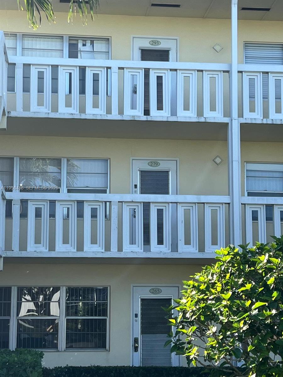 293 Dorset Drive, Unit G Boca Raton, FL 33434 - Photo 7 of 8 a front view of a building with balcony and garden