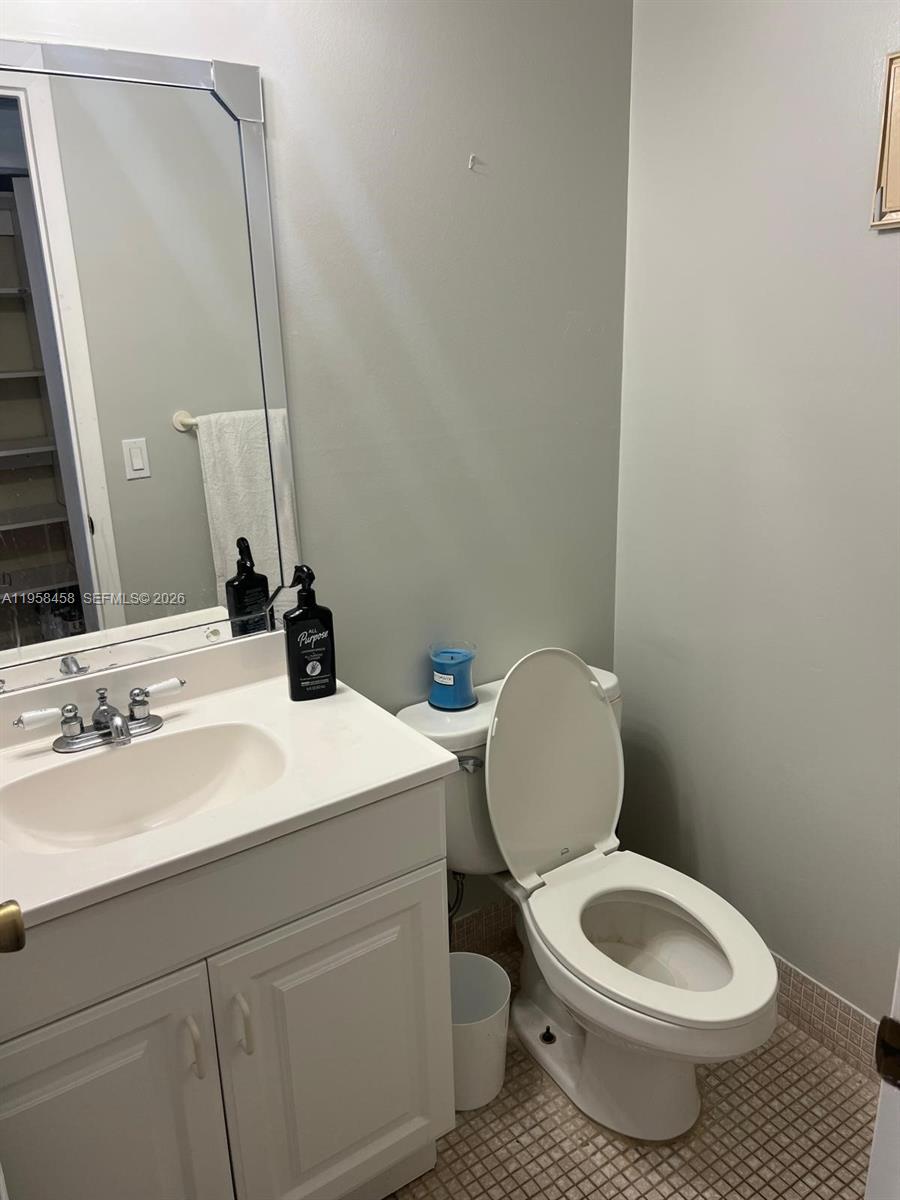 293 Dorset Drive, Unit G Boca Raton, FL 33434 - Photo 8 of 8 a bathroom with a toilet a sink and mirror