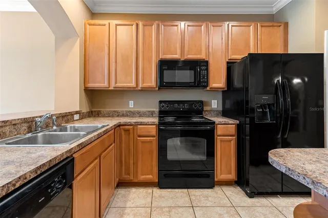 a living room with furniture a flat screen tv and kitchen view