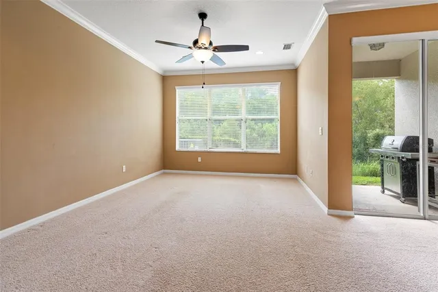 en empty room with windows and ceiling fan