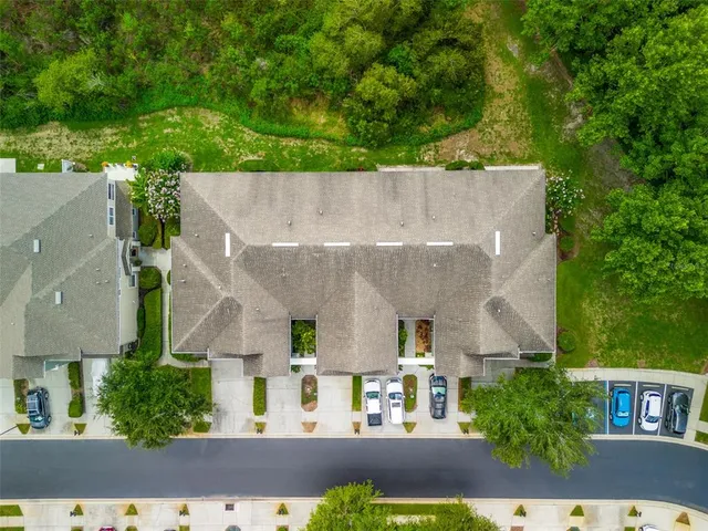 an aerial view of residential houses with outdoor space and trees