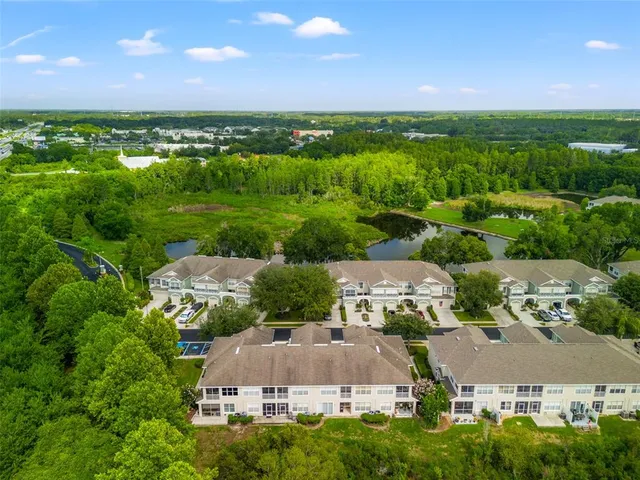an aerial view of a city with lots of residential buildings ocean and mountain view in back