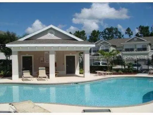 a view of a house with floor to ceiling windows and a garden