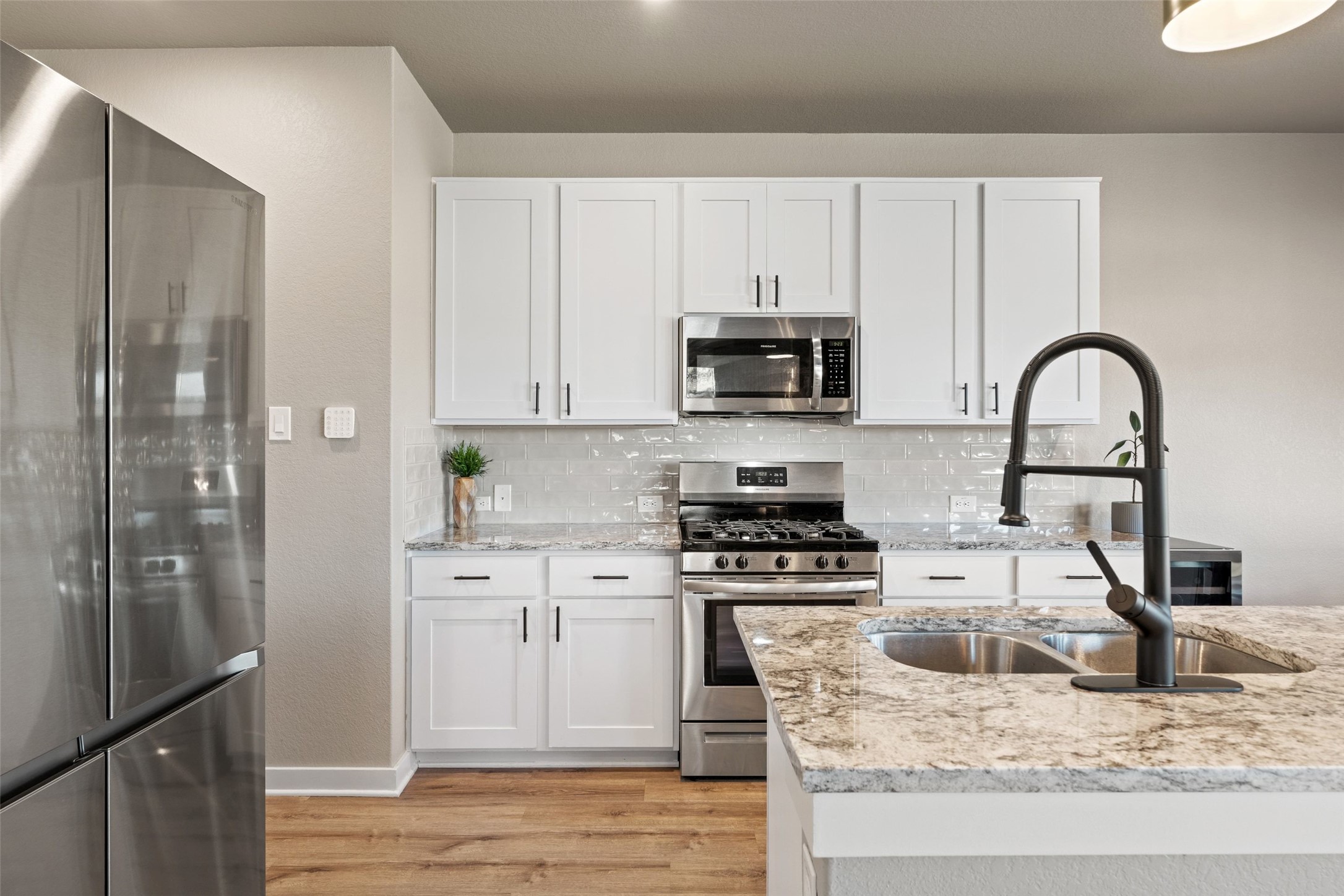 2251 Rocoso Trail Leander, TX 78641 - Photo 9 of 24 a kitchen with stainless steel appliances granite countertop a stove a sink dishwasher a refrigerator and cabinets with wooden floor
