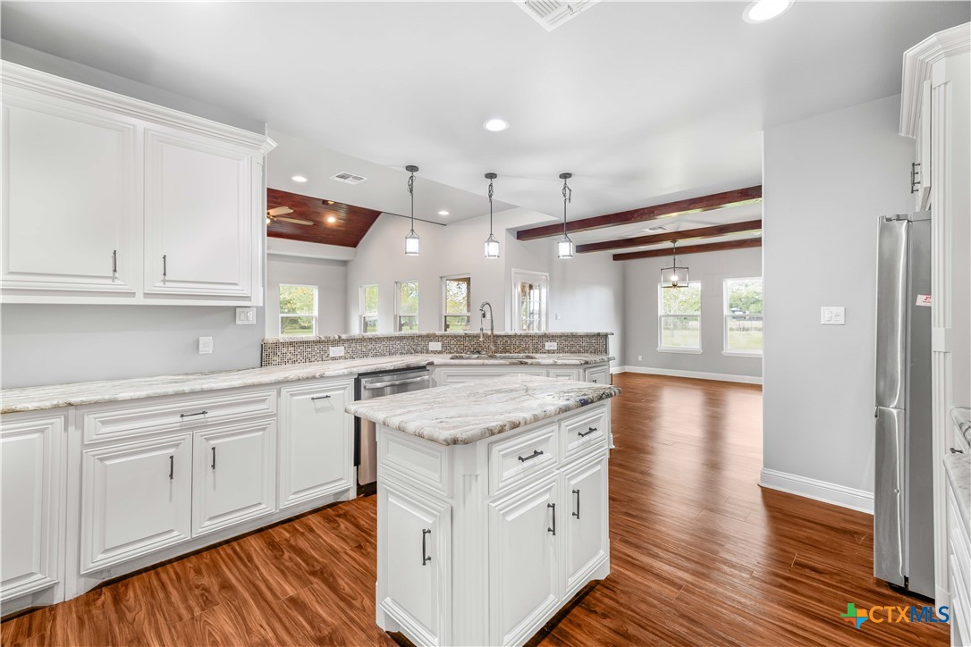 204 James Street Inez, TX 77968 - Photo 11 of 35 a kitchen with granite countertop a sink cabinets and wooden floor
