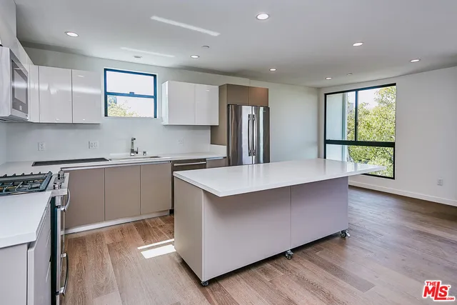 a kitchen with kitchen island a sink a stove a refrigerator and center island