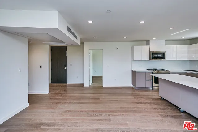 a view of kitchen with stainless steel appliances granite countertop a stove and a refrigerator