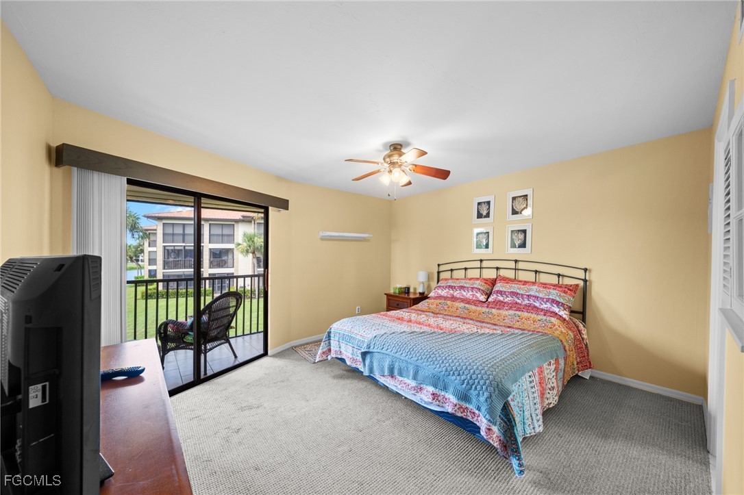 12581 Kelly Sands Way, Unit 518 Fort Myers, FL 33908 - Photo 20 of 33 a bedroom with a bed and a chandelier