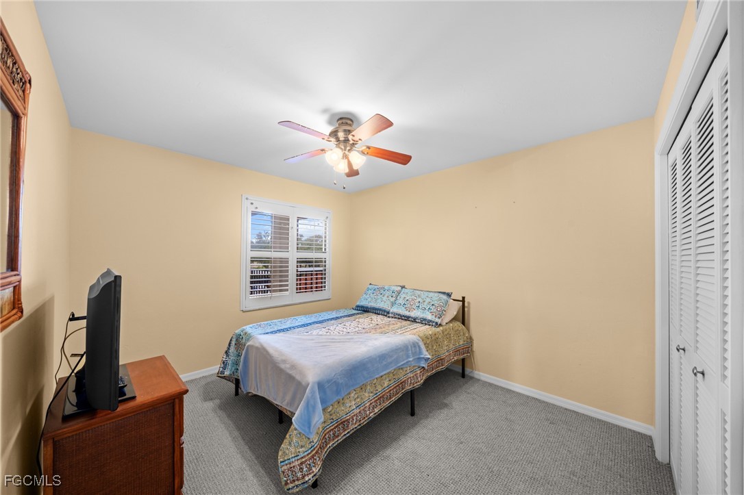 12581 Kelly Sands Way, Unit 518 Fort Myers, FL 33908 - Photo 24 of 33 a bedroom with a bed and a chandelier