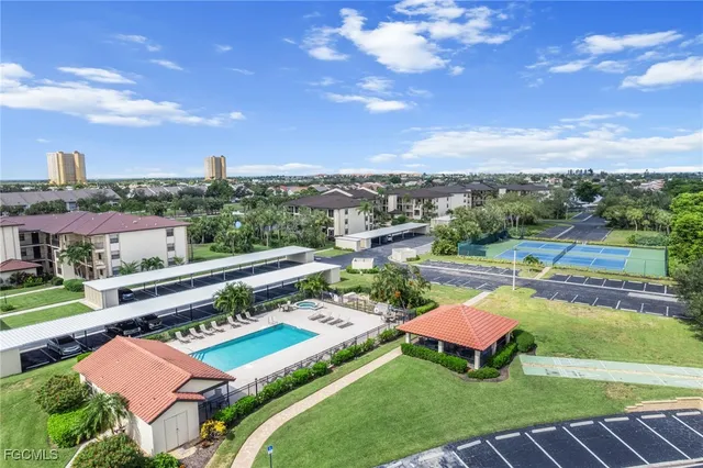 a view of a swimming pool with lawn chairs and a yard
