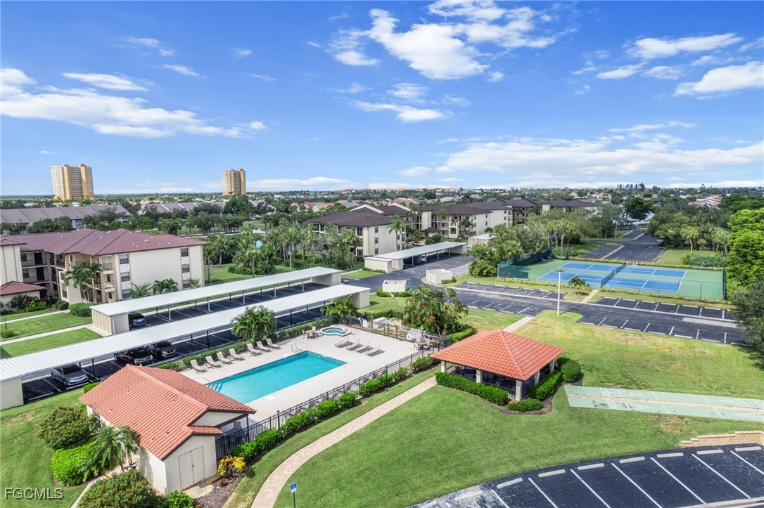 12581 Kelly Sands Way, Unit 518 Fort Myers, FL 33908 - Photo 30 of 33 a view of a swimming pool with lawn chairs and a yard