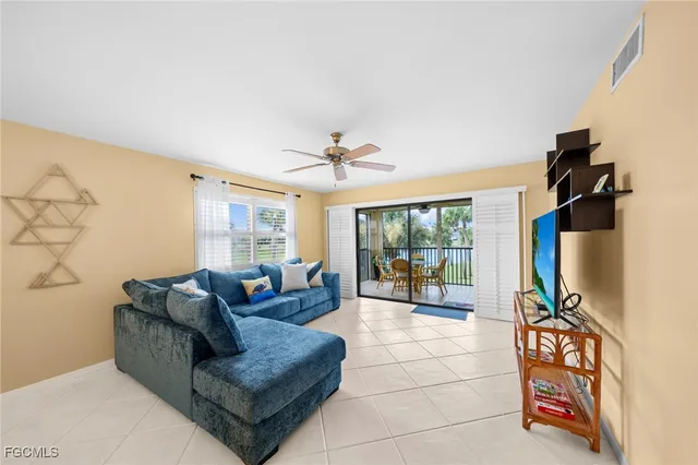 a living room with furniture a flat screen tv and a floor to ceiling window