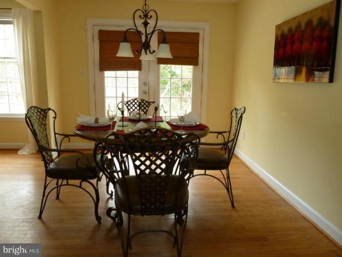 14424 Cantrell Road Silver Spring, MD 20905 - Photo 11 of 18 a dining room with furniture a large window and wooden floor