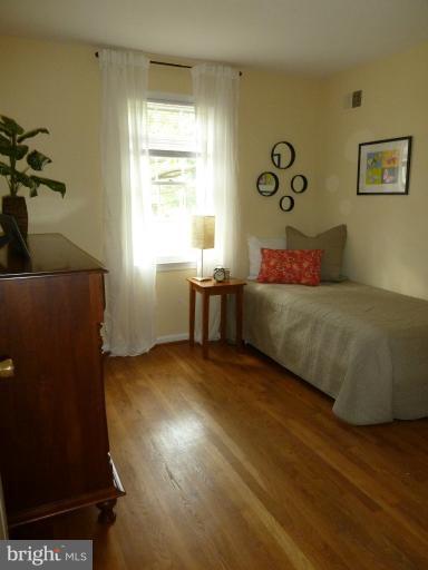 14424 Cantrell Road Silver Spring, MD 20905 - Photo 17 of 18 a bedroom with a bed and wooden floor