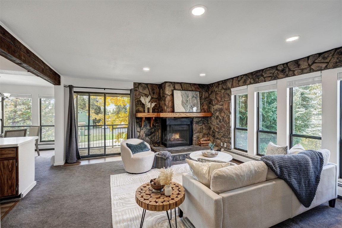 a living room with furniture large windows and a fireplace